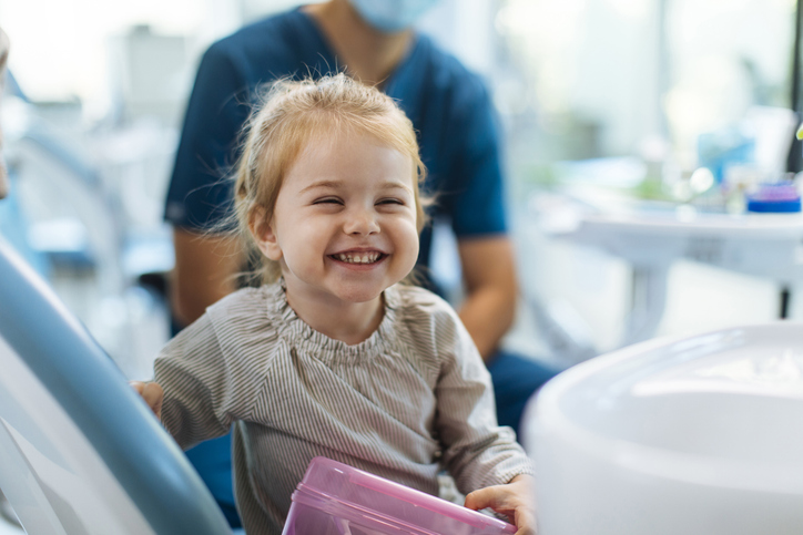 Child smiling at a dental health professional